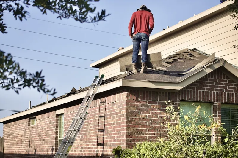 Professional roofer working on a residential roof in Mojonnier